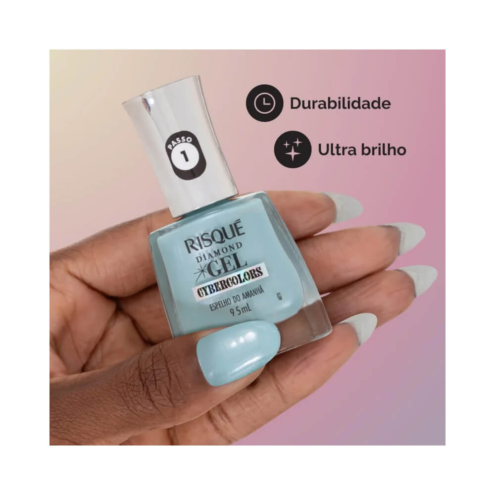 Mão com unhas pintadas com esmalte Risqué Diamond Gel Cybercolors Espelho do Amanhã, mostrando a cor azul clara e a textura do produto. Fundo rosa.